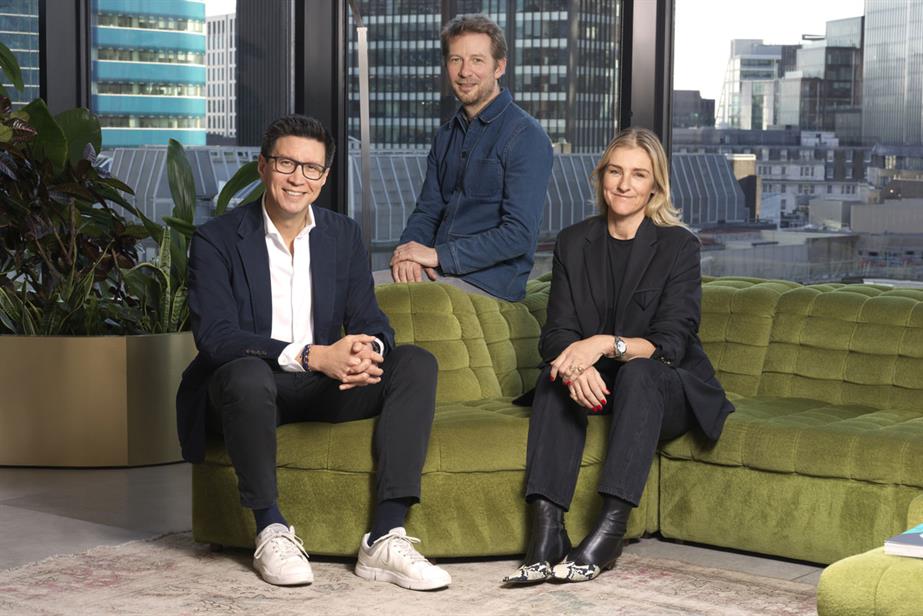 Photo of three people sat on a lime green sofa