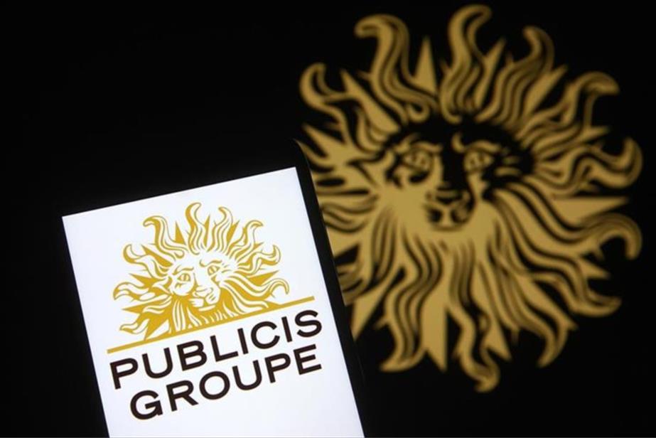 Publicis Groupe logo on a smartphone screen, while in the background the golden logo appears on a black backdrop