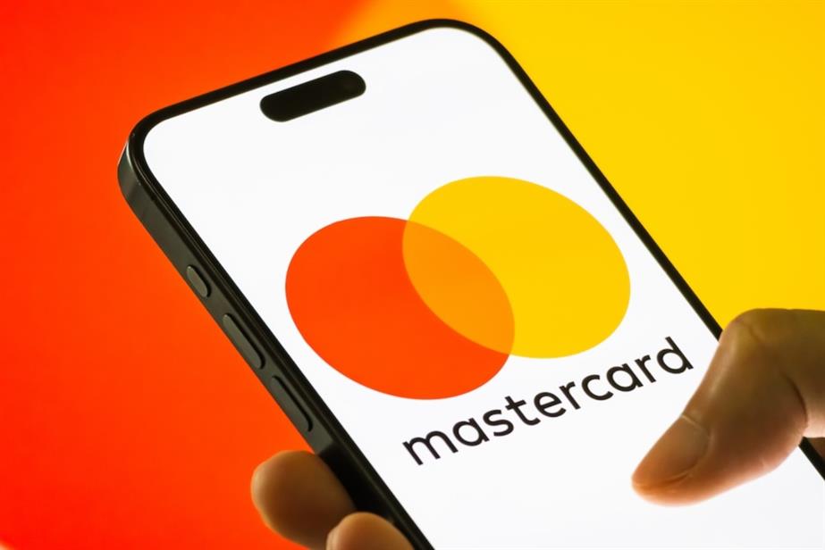 Hand holding smart phone displaying Mastercard logo