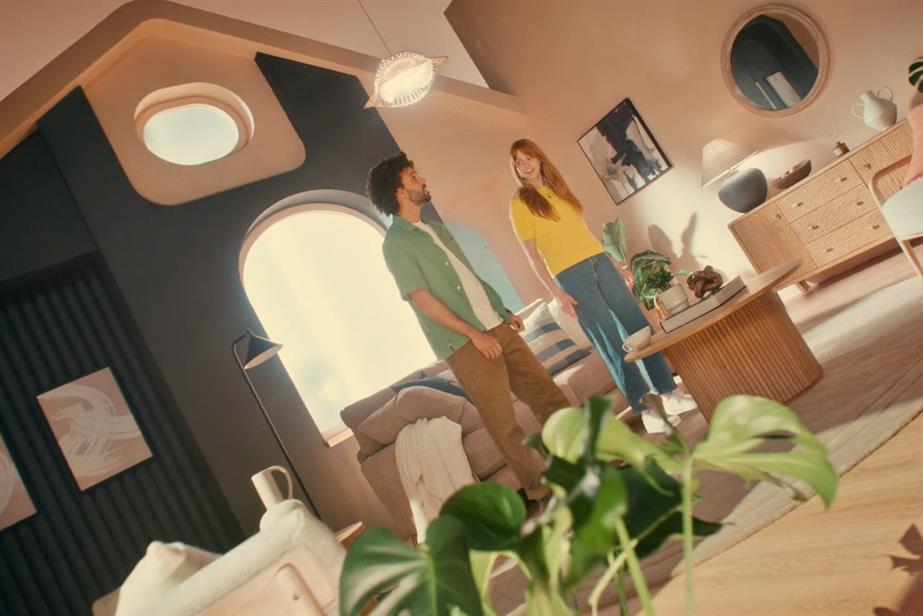 A man and a woman stand in their flat