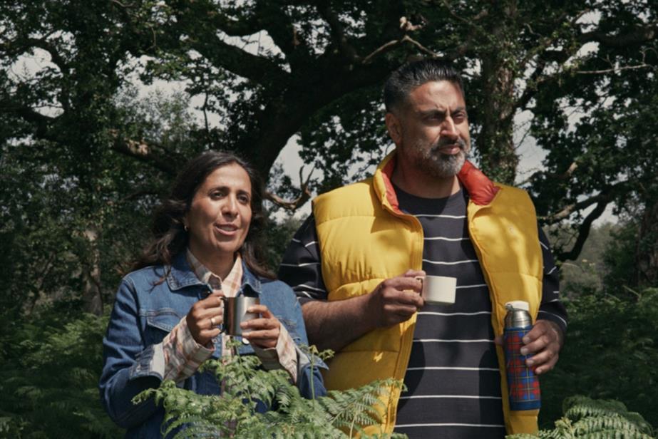 Couple enjoying drinks by trees and bushes
